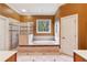 Spacious bathroom with a garden tub and a glass enclosed shower, complemented by neutral-colored tiles and a window view at 963 Manor Parc Dr, Decatur, GA 30033