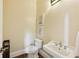 Classic powder room featuring a pedestal sink, hardwood floors, and neutral decor at 963 Manor Parc Dr, Decatur, GA 30033