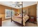 Comfortable bedroom features a ceiling fan, window view, and stylish four-poster bed with unique patterned pillows at 963 Manor Parc Dr, Decatur, GA 30033