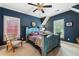 Stylish blue bedroom showcasing bed with unique patterns, a ceiling fan, and sunny windows with charming white shutters at 963 Manor Parc Dr, Decatur, GA 30033