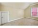 Neutral bedroom offers plush carpet, a built-in storage door, and natural light from a window at 963 Manor Parc Dr, Decatur, GA 30033