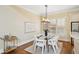 Bright dining room features white chairs, modern lighting fixture, and hardwood floors at 963 Manor Parc Dr, Decatur, GA 30033