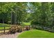Expansive backyard with a manicured lawn, bordered by mature trees and an idyllic wooden fence at 1348 Bridgemill Ave, Canton, GA 30114