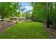 View of backyard with grass and mature trees with house in the background at 1348 Bridgemill Ave, Canton, GA 30114
