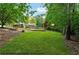 Backyard has flat grass for putting green, surrounded by mature trees and shrubs at 1348 Bridgemill Ave, Canton, GA 30114