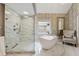 Beautiful bathroom features a modern standalone tub, glass enclosed shower with marble surround and stylish wallpaper at 1348 Bridgemill Ave, Canton, GA 30114