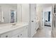 Bright bathroom featuring white cabinets, a large mirror, and a doorway into a charming bedroom at 1348 Bridgemill Ave, Canton, GA 30114