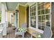 Inviting front porch with chairs, pillows, and large windows, perfect for relaxing outdoors at 1348 Bridgemill Ave, Canton, GA 30114
