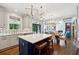 Open kitchen featuring a large center island, marble backsplash, and elegant light fixtures overlooking dining and living areas at 1348 Bridgemill Ave, Canton, GA 30114