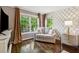 Sitting area featuring neutral love seat, decorative wallpaper, hardwood floors, and natural light at 1348 Bridgemill Ave, Canton, GA 30114