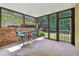 Enclosed sunroom with stone wall and bar-height seating overlooking backyard at 1348 Bridgemill Ave, Canton, GA 30114