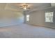 Spacious bedroom featuring a tray ceiling, ceiling fan, and large windows for ample light at 281 Chiswick Loop, Stockbridge, GA 30281