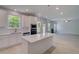 Open kitchen with stainless appliances and quartz island overlooking the living room with a fireplace at 281 Chiswick Loop, Stockbridge, GA 30281