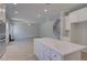 Modern kitchen with stainless appliances and quartz counters adjacent to a large living room with staircase at 281 Chiswick Loop, Stockbridge, GA 30281
