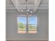 Elegant living room with a modern chandelier, large windows, and hardwood floors at 281 Chiswick Loop, Stockbridge, GA 30281