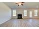 Spacious living room featuring wood flooring, a fireplace, multiple windows, and a ceiling fan at 281 Chiswick Loop, Stockbridge, GA 30281