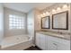 Bathroom with a double vanity, framed mirrors, granite countertops, and a tub at 363 Chadwick Cmn, Stockbridge, GA 30281