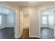 Hallway featuring three doors to a bedroom and bathroom with hardwood flooring at 363 Chadwick Cmn, Stockbridge, GA 30281