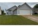 View of the home with a two-car garage and a manicured lawn at 363 Chadwick, Stockbridge, GA 30281