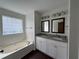Main bathroom featuring a soaking tub, double vanity, and a glass block window for natural light at 363 Chadwick, Stockbridge, GA 30281