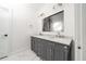 Bathroom featuring a dual sink vanity with marble countertop and stylish mirror at 140 Racine Sw St, Atlanta, GA 30314