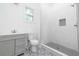 Modern bathroom with a gray vanity, walk-in shower with white tile, and patterned tile flooring at 140 Racine Sw St, Atlanta, GA 30314