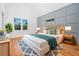 Serene primary bedroom featuring a blue accent wall, hardwood floors, and bright windows at 140 Racine Sw St, Atlanta, GA 30314