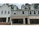 Close-up view of newly constructed townhomes with attached garages, featuring varied textures and architectural details at 162 Bluffington Way, Marietta, GA 30066