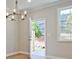 A brightly lit living room with wood floors, modern light fixture, exterior door and window at 162 Bluffington Way, Marietta, GA 30066