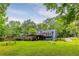 Large, lush green backyard with expansive wood deck and mature trees at 288 Shire Way, Lawrenceville, GA 30044