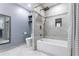 Updated bathroom features a tub with tiled surround, a rainfall shower head, and stylish floating shelves at 288 Shire Way, Lawrenceville, GA 30044