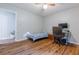 Bedroom featuring wood floors and desk setup with view to adjoining room at 288 Shire Way, Lawrenceville, GA 30044