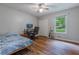 Bedroom featuring wood floors, a ceiling fan and closet with desk setup near window at 288 Shire Way, Lawrenceville, GA 30044