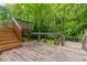 Wooden deck with staircase to green yard, mature landscaping, and wood railing at 288 Shire Way, Lawrenceville, GA 30044