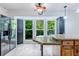Bright kitchen with granite island, black refrigerator, and a window overlooking a green and woodsy area at 288 Shire Way, Lawrenceville, GA 30044
