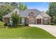 Charming brick home featuring a manicured lawn, lush landscaping, and a welcoming front porch at 5791 Epping Ct, Douglasville, GA 30135
