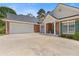 Spacious garage and wide driveway, green lawn, and manicured landscaping at 5791 Epping Ct, Douglasville, GA 30135