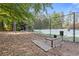 A community tennis court in a wooded setting with a bench and ball machine at 5791 Epping Ct, Douglasville, GA 30135