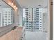 Bright bathroom features double sink vanity, grey floor, and city view at 950 W Peachtree Nw St # 911, Atlanta, GA 30309