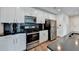 Modern kitchen featuring white cabinets, stainless steel appliances, and dark backsplash tiles at 950 W Peachtree Nw St # 911, Atlanta, GA 30309