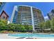 Beautiful pool with building views, landscaping, and lounge chairs under a sunny blue sky at 950 W Peachtree Nw St # 911, Atlanta, GA 30309