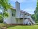 Back exterior view showcasing a deck, stairs to the yard, and a well-maintained lawn at 100 Sydney Smt, Villa Rica, GA 30180
