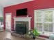 A stone fireplace with a white mantel, TV, and large windows creating a warm atmosphere at 100 Sydney Smt, Villa Rica, GA 30180