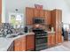 A partial view of the kitchen area with wood cabinets, stainless steel appliances and tile countertops at 100 Sydney Smt, Villa Rica, GA 30180
