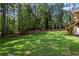 Spacious backyard featuring a lush green lawn and a charming wooden deck and stairs at 10350 Alvin Rd, Johns Creek, GA 30022