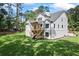 Back view of home featuring a raised wooden deck, brick foundation, and large, grassy yard at 10350 Alvin Rd, Johns Creek, GA 30022