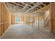 Unfinished basement with wood framing, concrete floors, with window to the yard, and stairs leading to upper level at 10350 Alvin Rd, Johns Creek, GA 30022