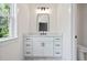 Stylish bathroom vanity with white cabinets, modern black hardware, and a sleek rectangular mirror at 10350 Alvin Rd, Johns Creek, GA 30022