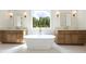 Gorgeous bathroom features marble floors, dual vanities, freestanding tub, and window view at 10350 Alvin Rd, Johns Creek, GA 30022
