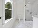 Bright bathroom with a large window, glass shower, and marble floors at 10350 Alvin Rd, Johns Creek, GA 30022